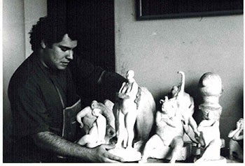 Item #51-0620 Photograph of the Artist with sculptures holding la Mujer del Circo. Armando Romero.
