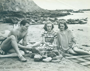 Bachrach, Ernest A. (phot.); RKO Radio Pictures - Cameraman Peeks-in on Hollywood Beach Party (No. 3). Promotional Photograph of Anne Shirley, Ruby Keeler & James Ellison for Rko Radio's 1938 Film, Mother Carey's Chickens