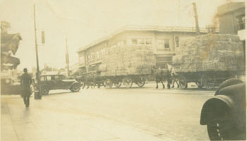 Early 20th Century American Photographer - B&W Photograph of Intersection with Hay-Stacked Horse-Drawn Carriages and Packards