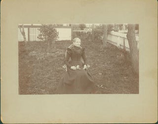 Item #63-2642 Photograph of seated elderly lady in black dress, holding flowers in her lap. 19th...