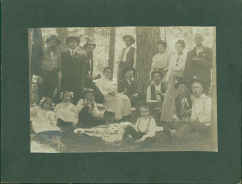 Item #63-2643 Photograph of a picnic in the woods with nine men, three women and four children total, seated and standing. 19th Century American Photographer.