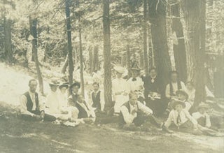 Item #63-2672 Photograph of a picnic in the woods, people seated below small American flag. 19th...