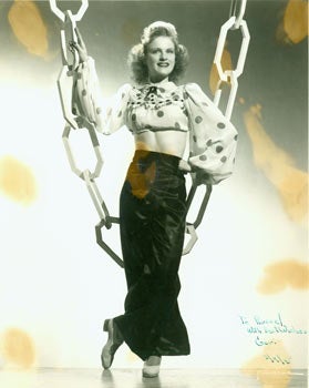 Item #63-2727 Black and White Photograph of woman on stage, with prop chains. Dated original autograph dedication "To Russel, With Best Wishes, Geri, 2/9/45." Romaine Photography, CA San Francisco.