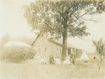 Item #63-2735 Monochrome Photograph of a family seated & standing in front of a tree outside of their house. 19th Century American Photographer.
