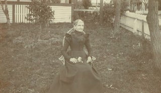 Item #63-2754 Monochrome Photograph of a woman seated in chair in backyard formally dressed...