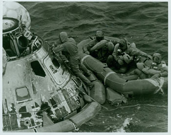 National Aeronautics and Space Administration - Nasa Apollo 11 Photograph: Apollo 11 Pacific Recovery Area -- Pararescueman Lt. Clancey Hatleberg Closes the Apollo 11 Spacecraft Hatch As Astronauts Neil A. Armstrong, Michael Collins and Edwin E. Aldrin, Jr. , Await Helicopter Pickup from Their Life Raft (July 24, 1969). First Edition