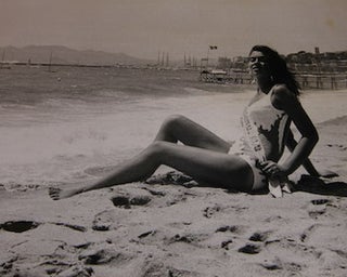 Item #68-0431 Miss Festival sitting on the beach. Photograph from the 1970 Cannes Film Festival....